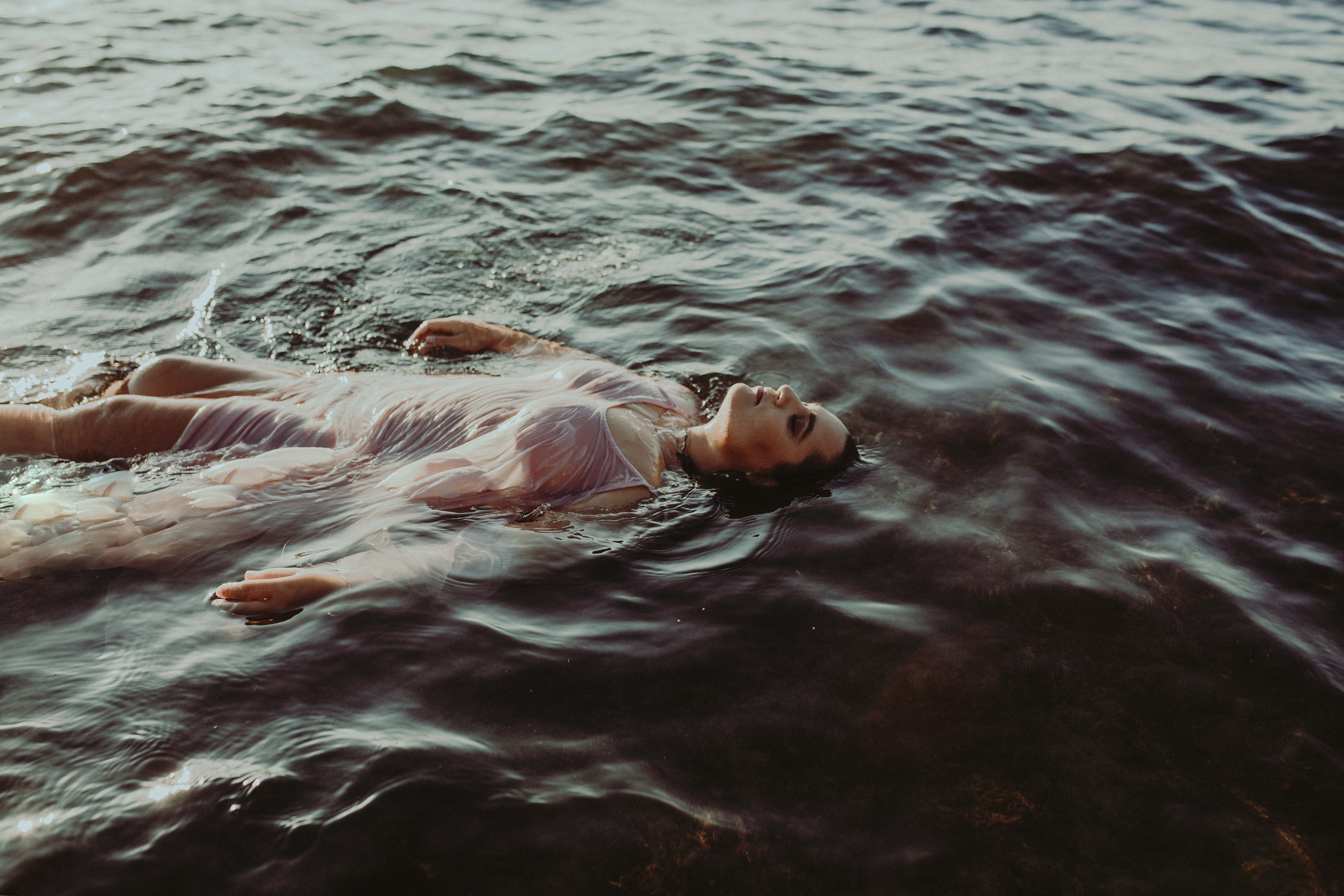Wild woman floating in the ocean at sunrise in hawaii