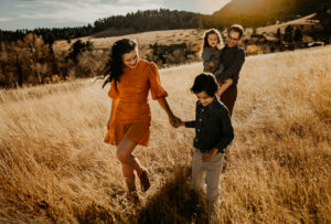 family with two children exploring a field in Colorado