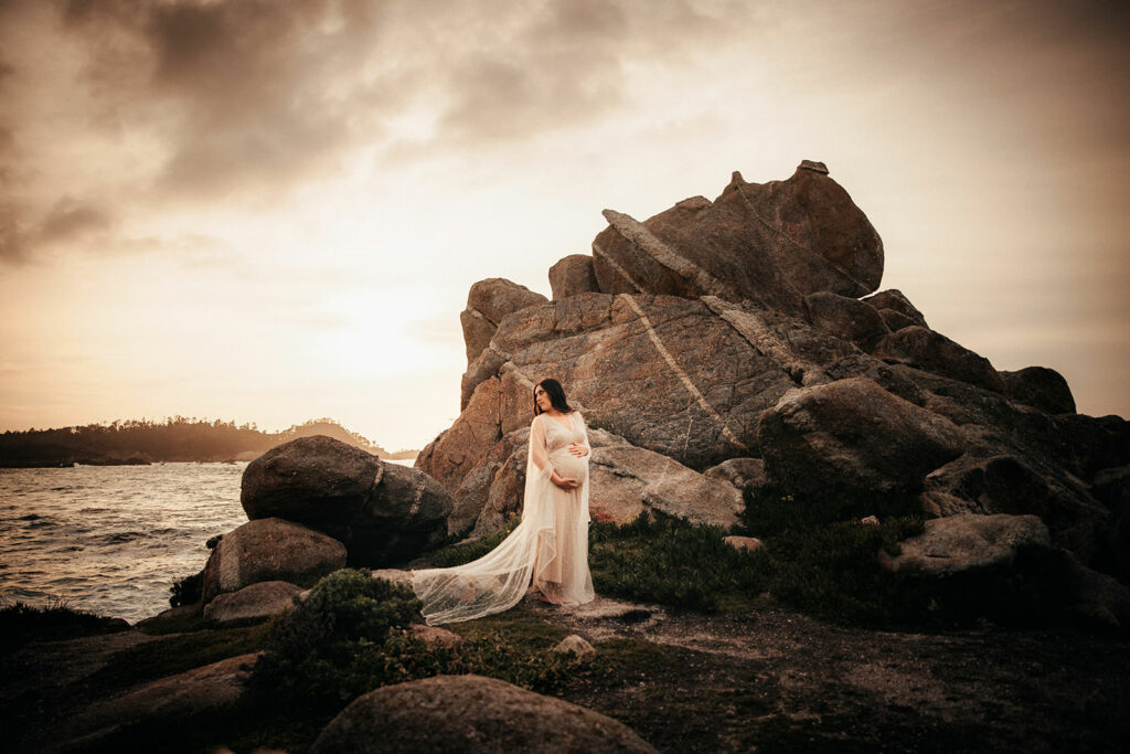 maternity session on a rock near the ocean